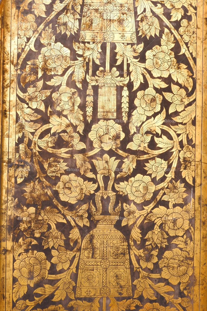 Painting on the wooden door of Wat Rakhang Kositaram Woramahawihan in Thailand There is a bell shaped which is the highlight of the temple.