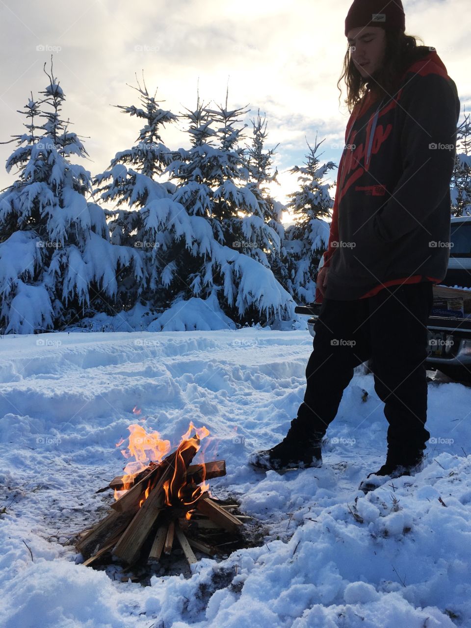 Man standing near campfire in winter