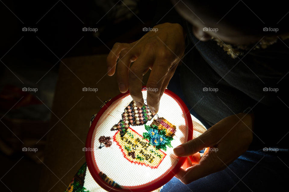 I love doing cross stitching and lockdown gave me time to get to it!  Image of woman doing broidery at night with cat and home sweet home flower scene.