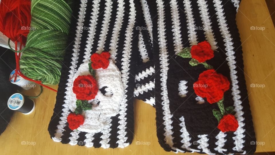 Getting ready for Dia de Los Muertos. I started with crocheting one scarf and ended up with many in different colors and designs but all with skulls.