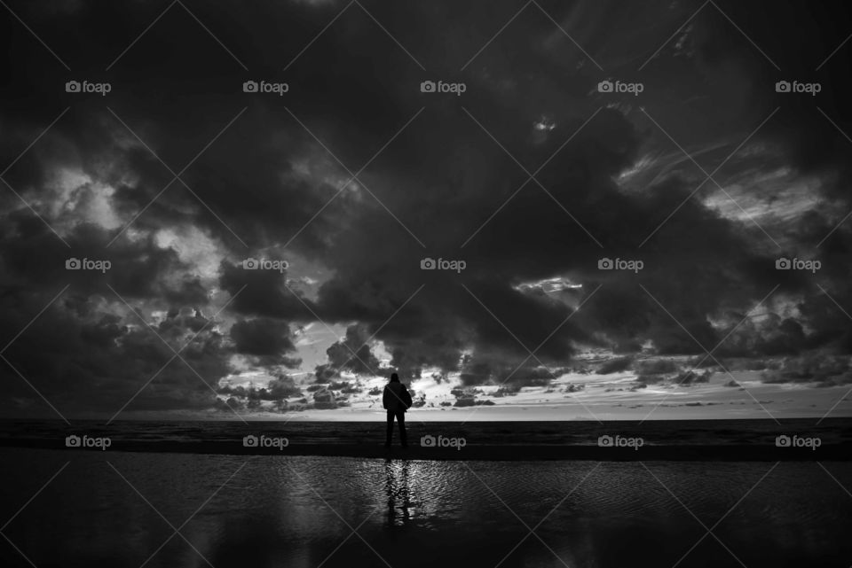 Dramatic sky and silhouette of people in black and white
