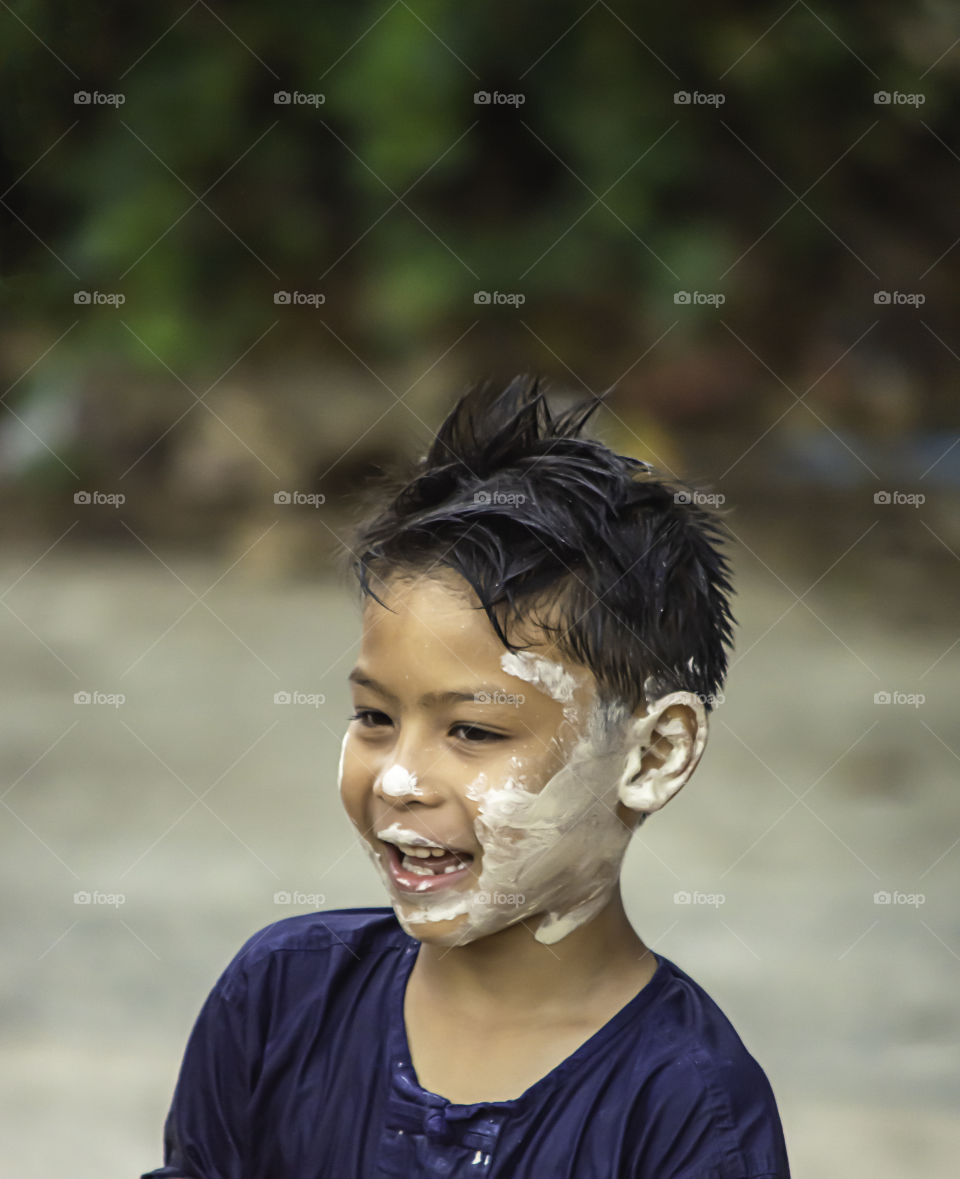 Asian boy play water and flour in Songkran festival or Thai new year in Thailand.