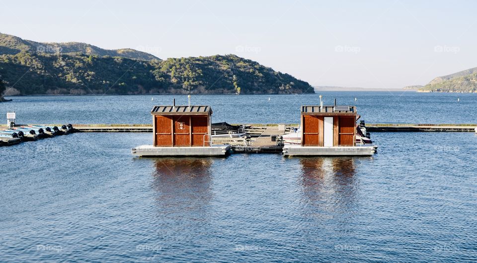 Two sheds on a lake at a boat dock