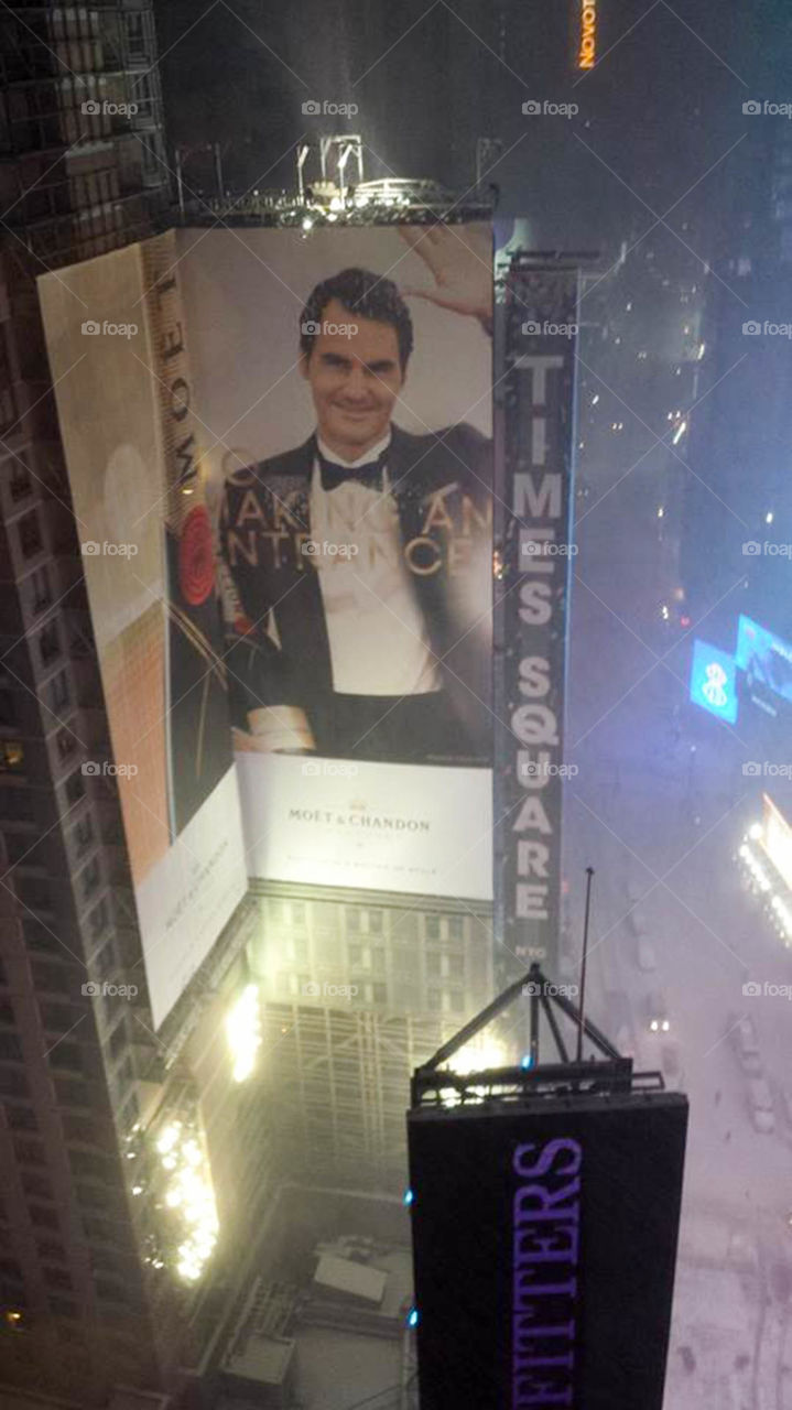 Times Square covered in snow. Times Square covered in snow right after New Years. Giant mural advertising Roger Federer, famous tennis player.