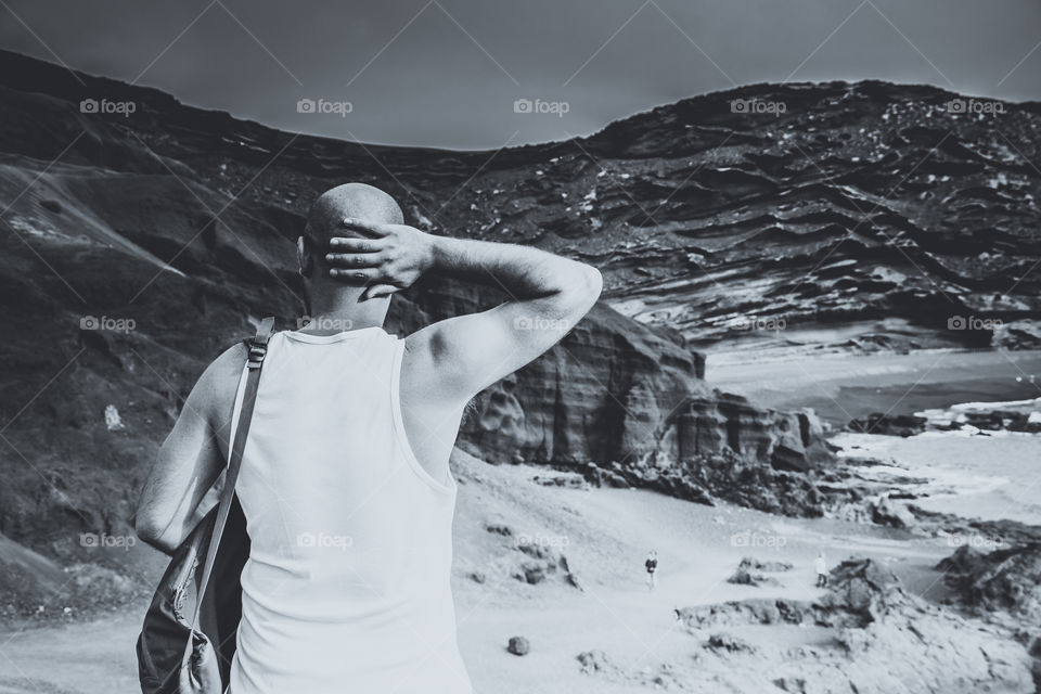 Bald man holding bag overlooking the mountains