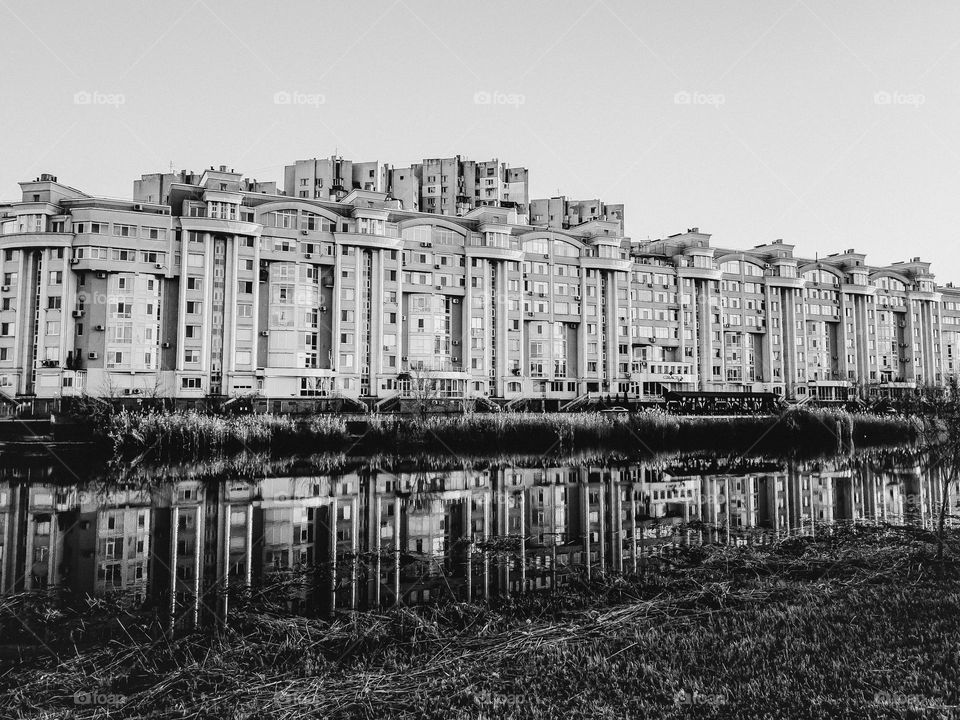 building near the lake in black and white color