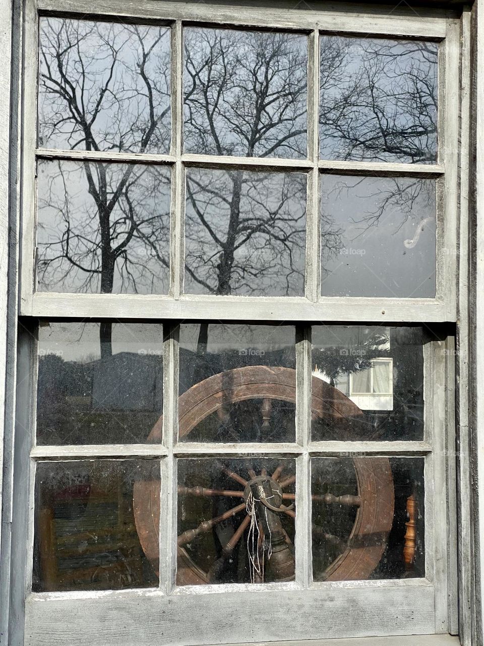 Looking through a window of an old house towards a spinning wheel