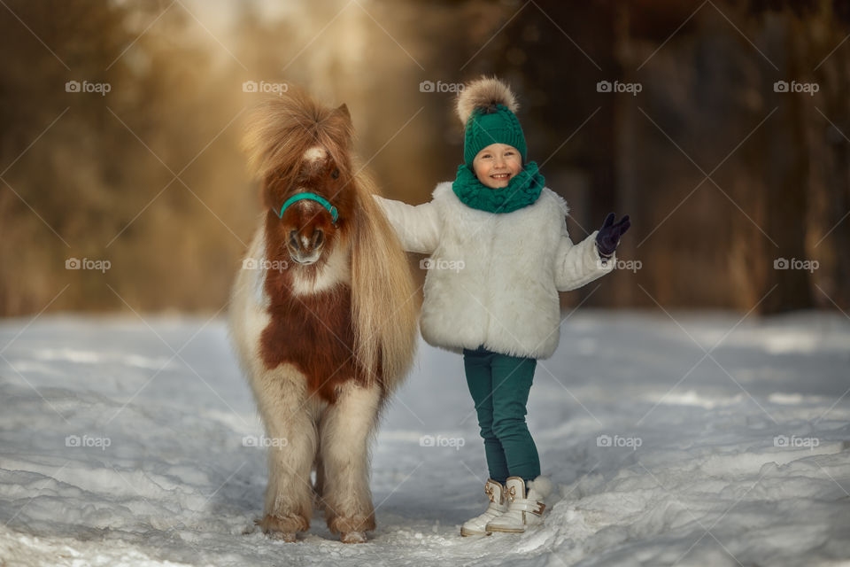 Little girl with pony at early spring day