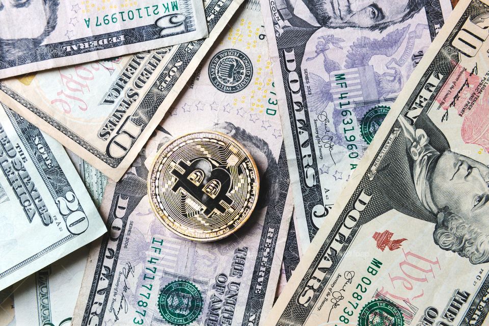 Moneda de Bitcoin en billetes de dinero en efectivo