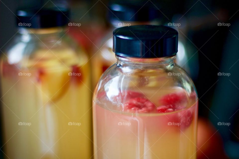 Closeup of kombucha, bottled for a second-ferment and flavored with nectarines and raspberries
