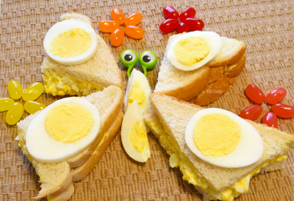 Egg Salad Sandwich on white bread, sliced in four triangles and decorated to look like a butterfly