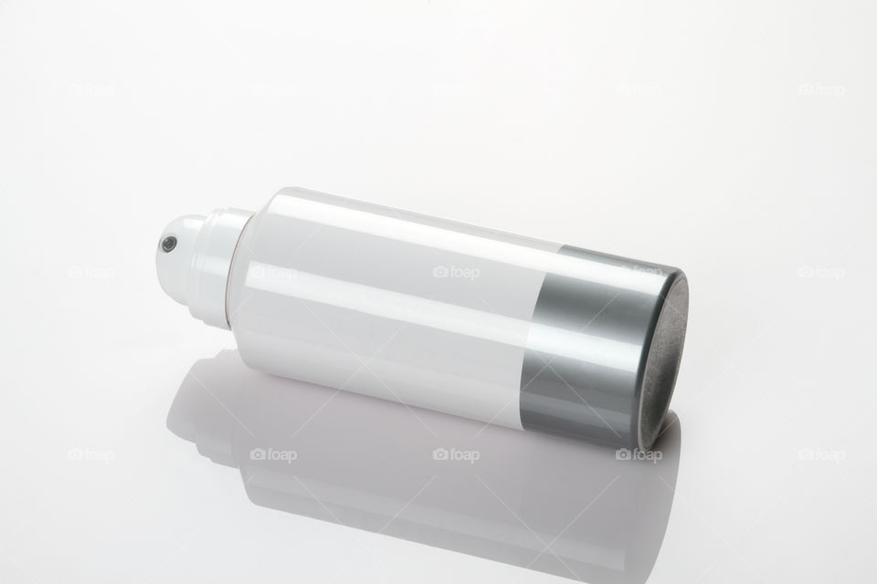 White deodorant spray can on white reflective background