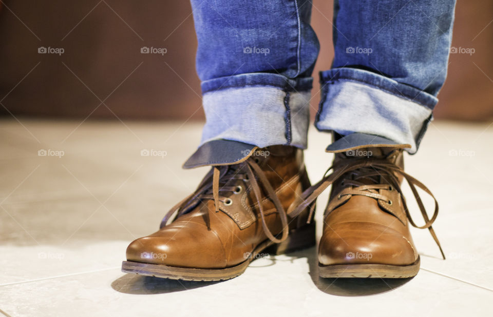 Low section of person wearing brown jeans