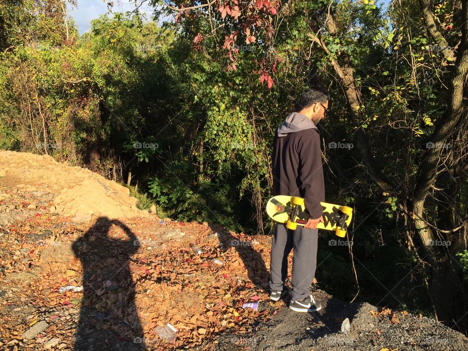 Skater's edge . Boyfriend standing at a cliff looking down on a forest in Easton, PA