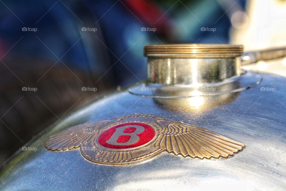 The badge and radiator cap of a vintage Bentley motor car.