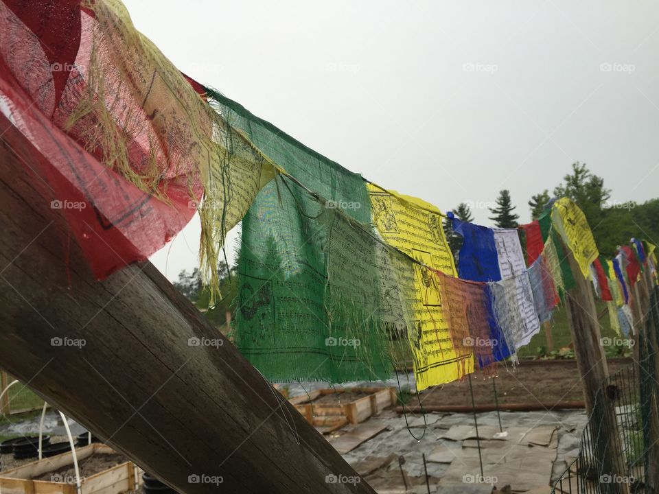 Old and new. Tibetan prayer flags on the garden fence