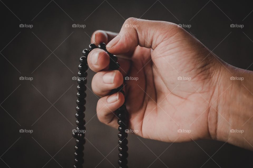 Close-up of hand holding prayer beads
