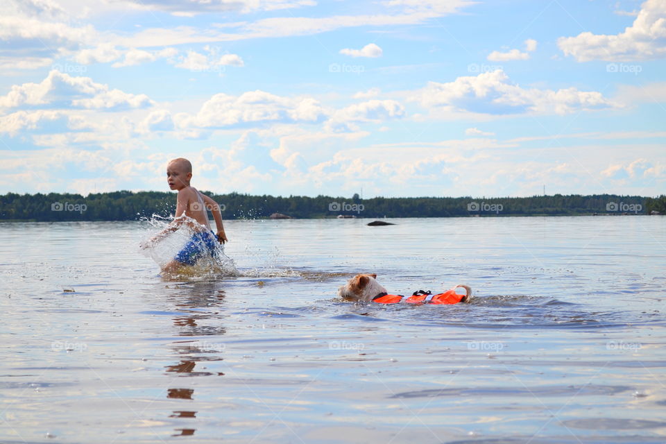 Boy playing with a dog in the water