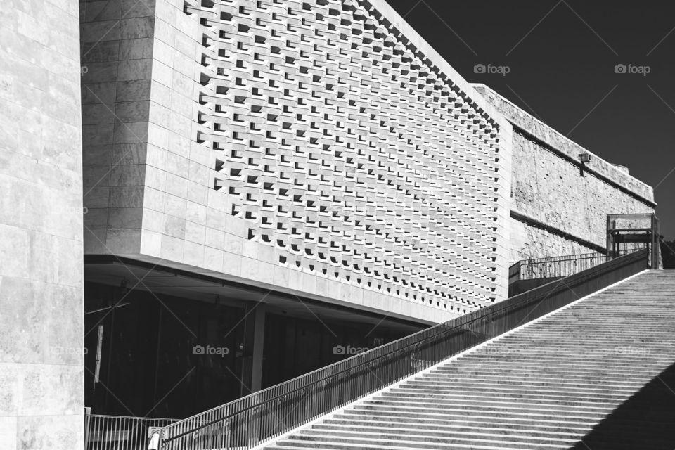 Parliament Building designed by Renzo Piano in Valletta, Malta, and an empty staircase at the side, in black and white.