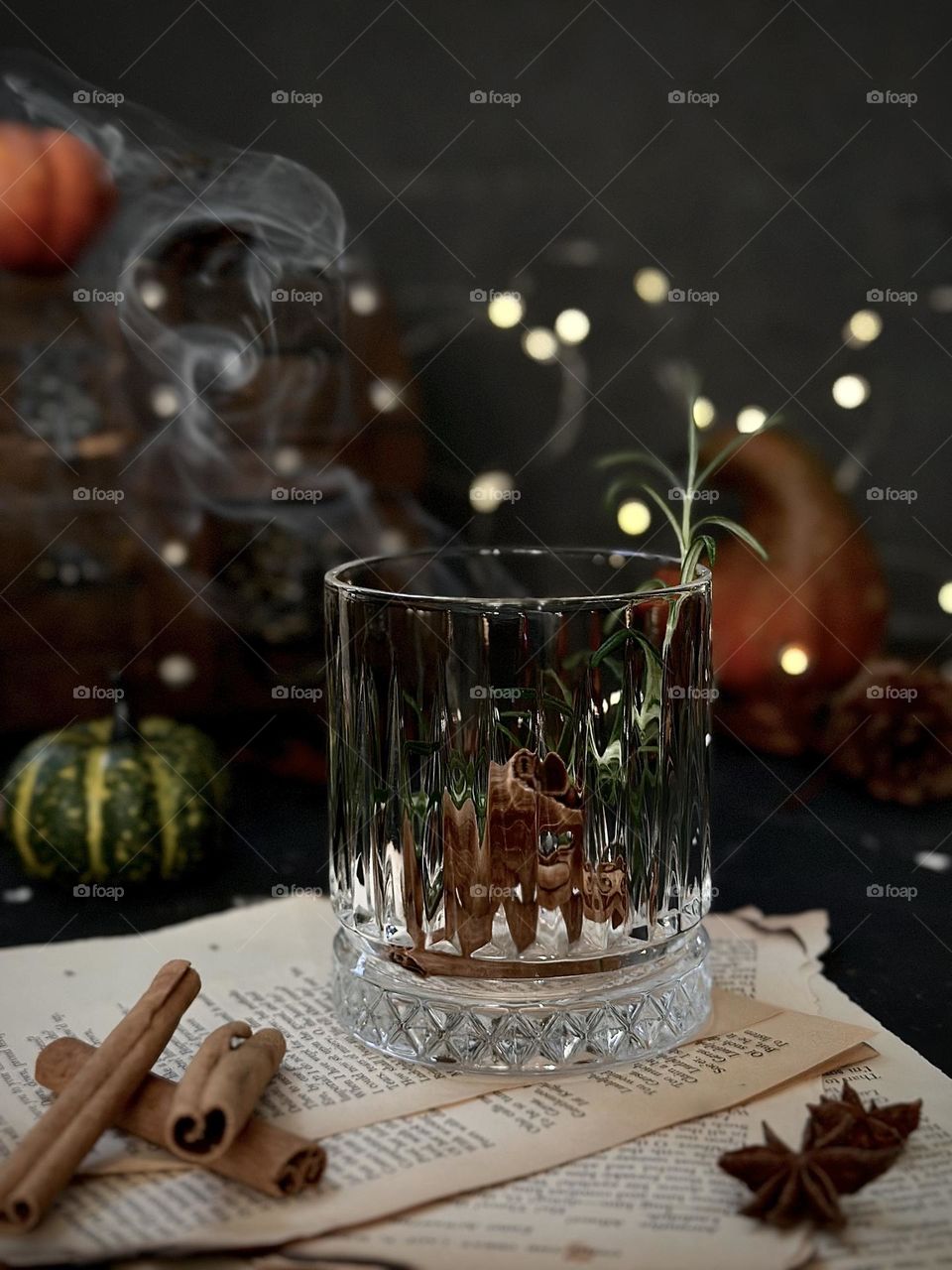 A glass with rosemary twig and cinnamon smoke