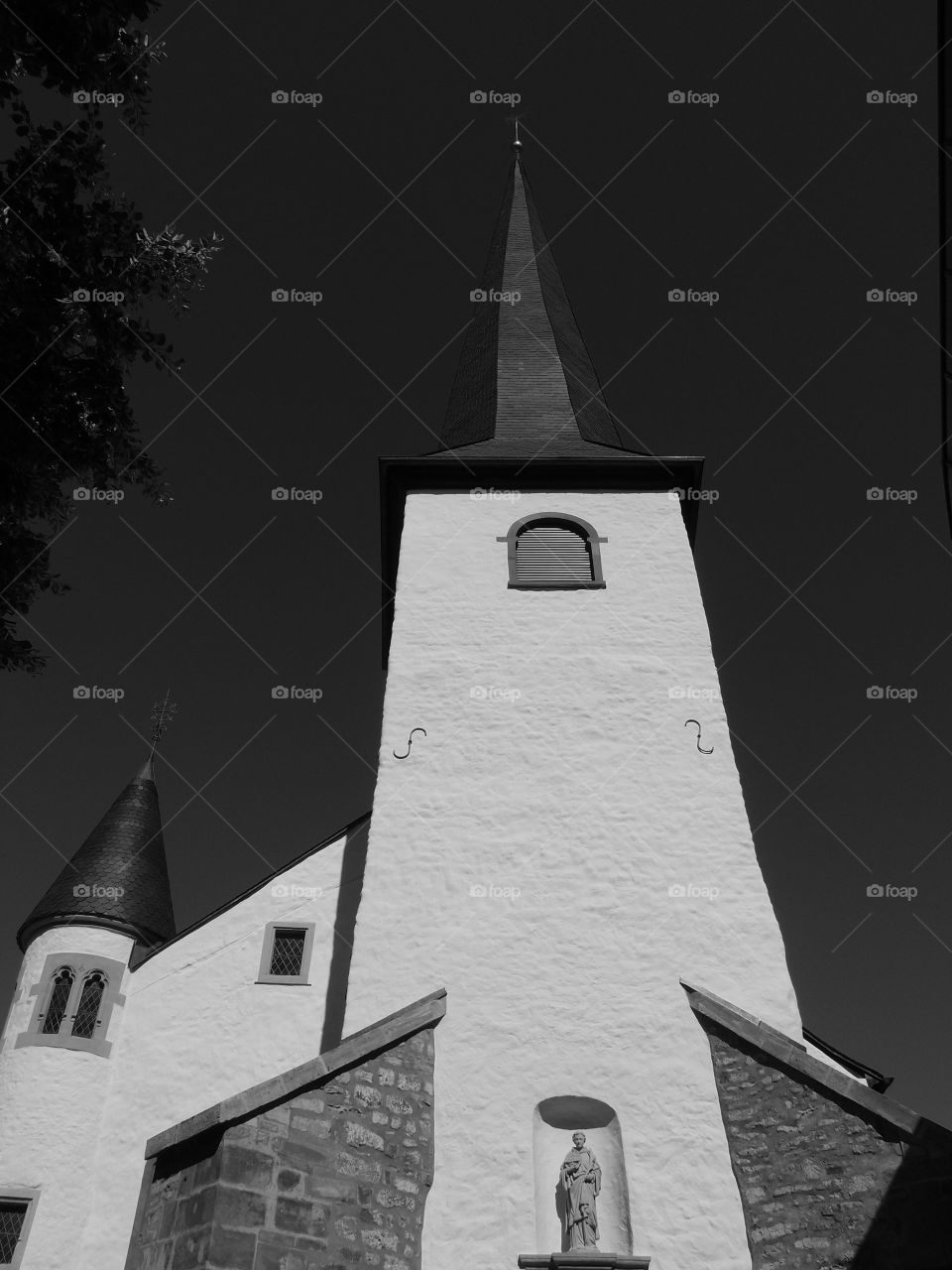 The magnificent black and white contrast of an old church against a clear summer sky. 