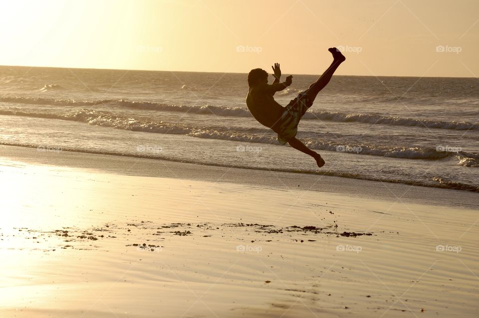 Man playing capoeira at sunset 