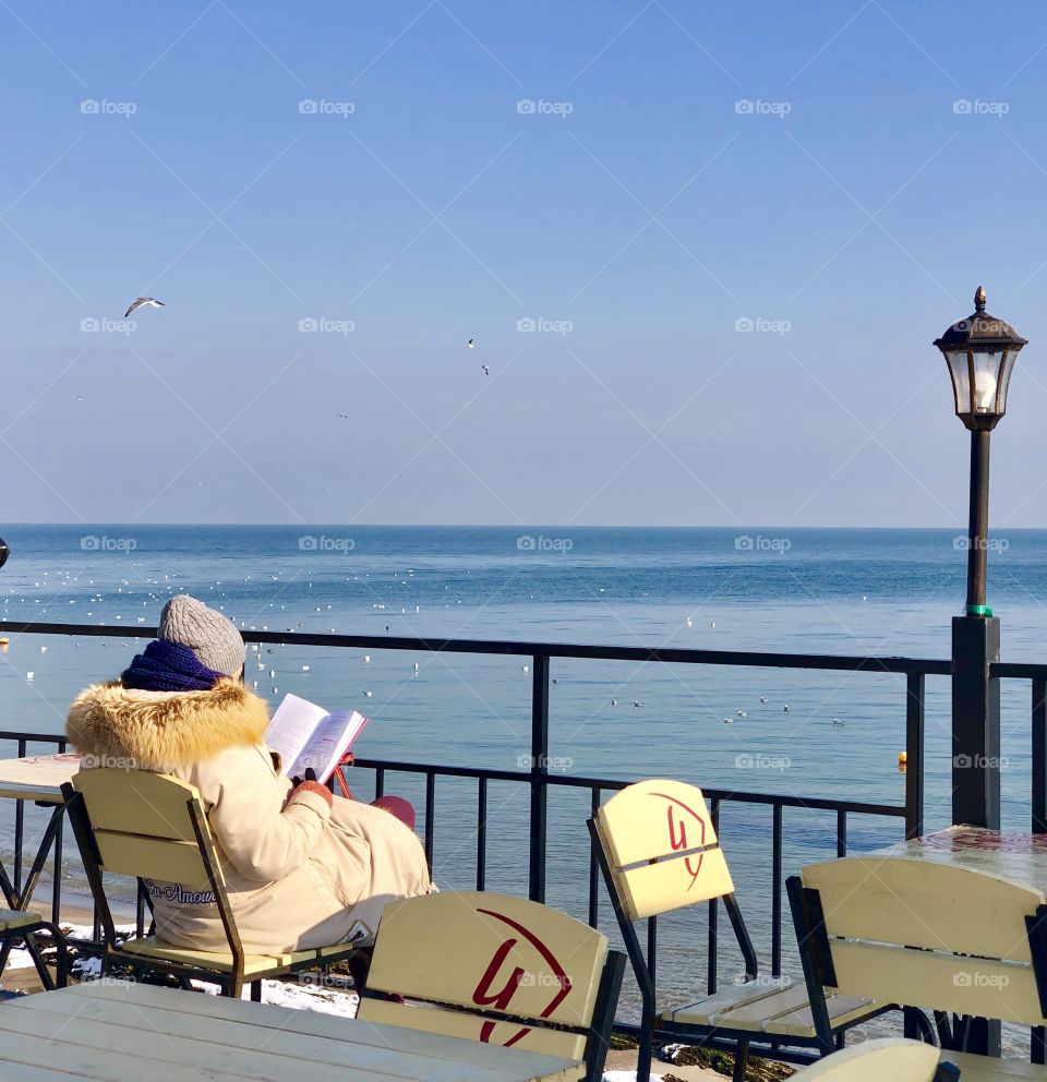 Reading girl in a winter sunny day near the sea