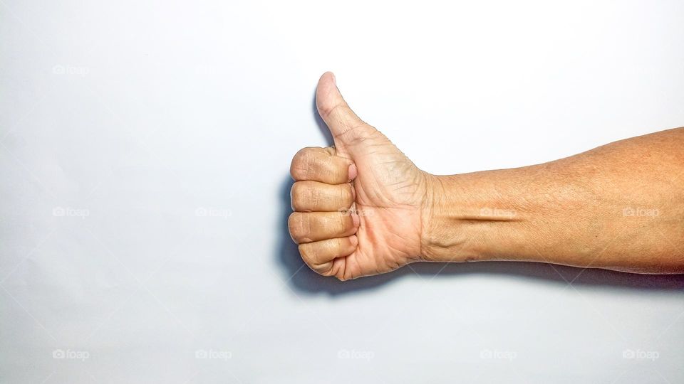 Hand showing thumbs up in eye level view