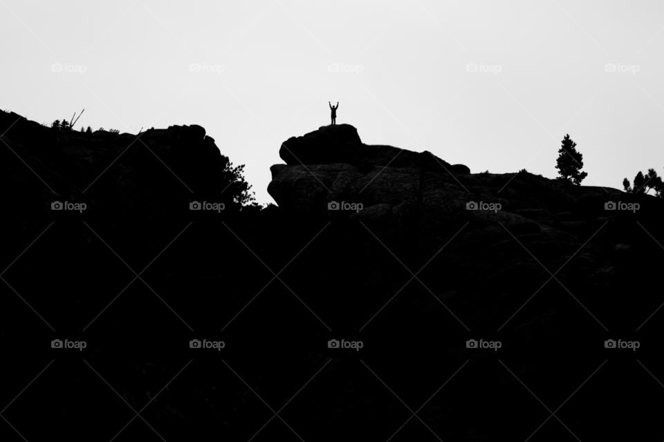 Man stand atop a mountain
