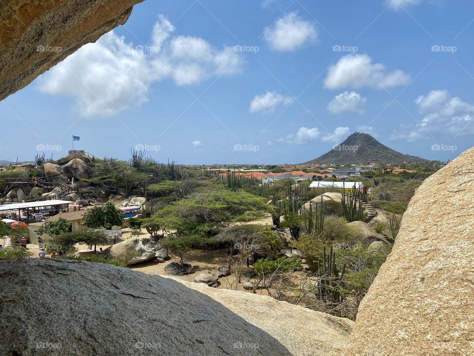 Looking through the gap between several large boulders towards a mountain in the distance