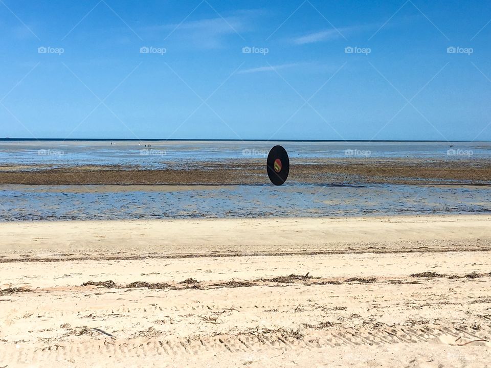 Vinyl music record flying through air at beach, beach scene rock and roll room
For copy