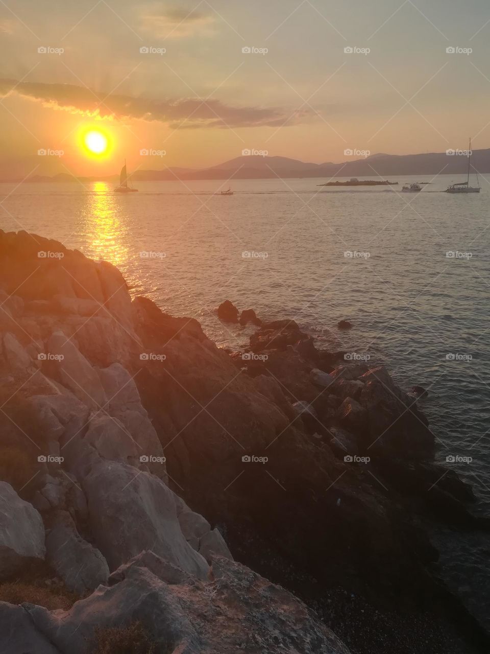 Shooting a view of a sunset on a greek island, Hydra, admiring sailboats from a distance
