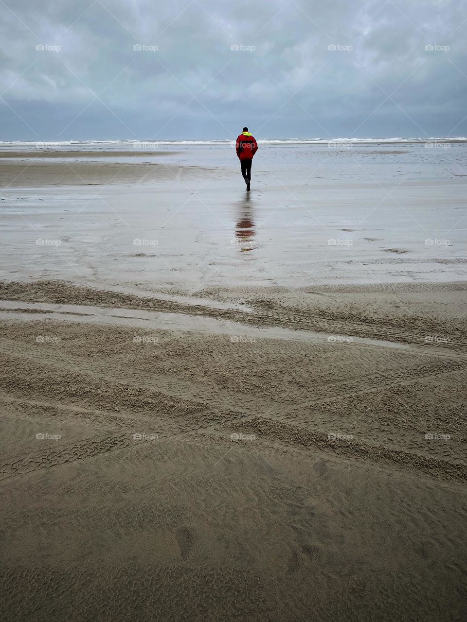Man walking all alone on the beach. Quiet environment, spacious, on the beach at Terschelling, quiet sea