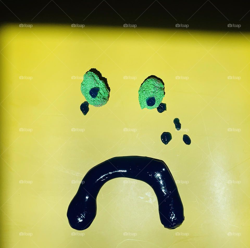 Slime Face With The Emotion That Reads As Really Sad With Tears On Yellow Background With Light And Shadow.