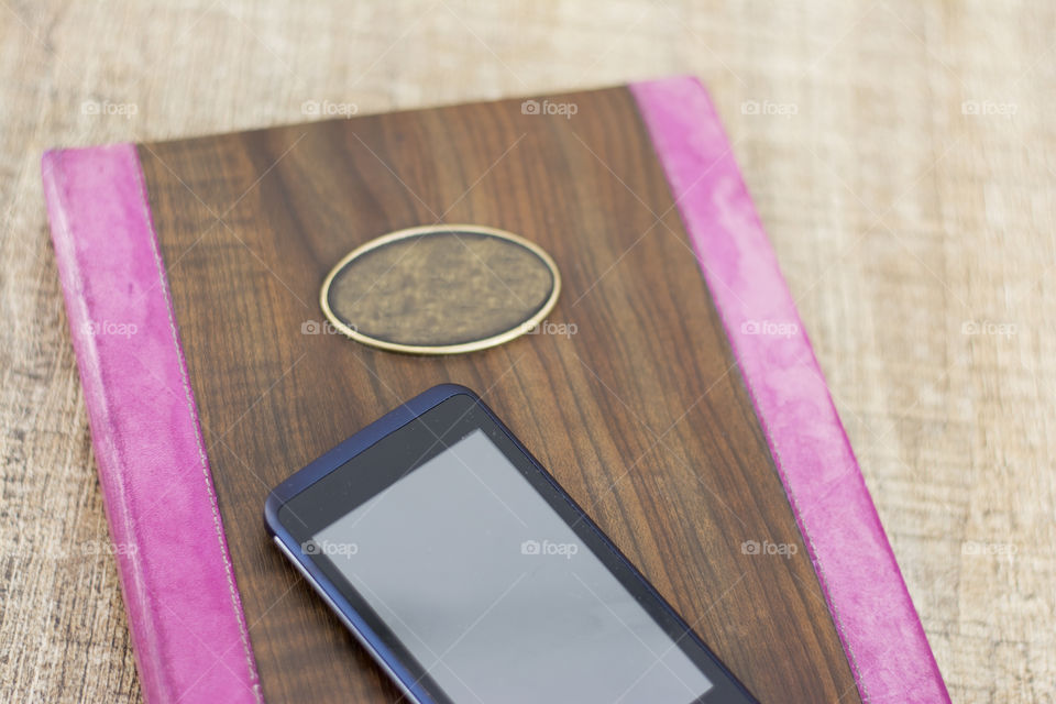 Little diary book with smartphone on top