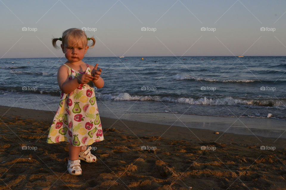 Little girl playing by the beach in the sunset in Turkey