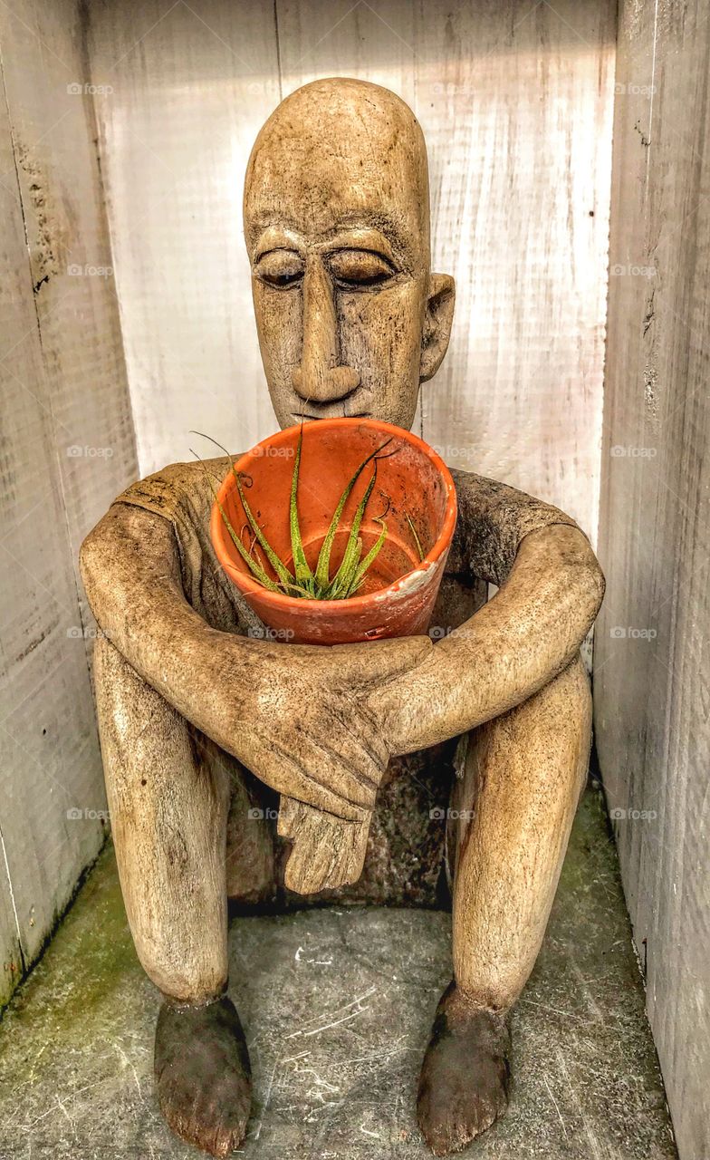 Sculpture holding flowerpot 
