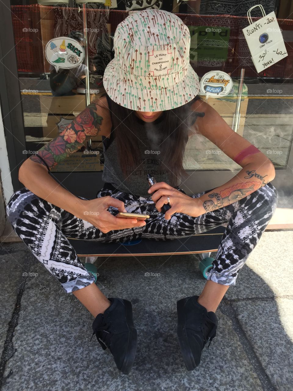 A sitting Woman with the arms full of Tattoo 