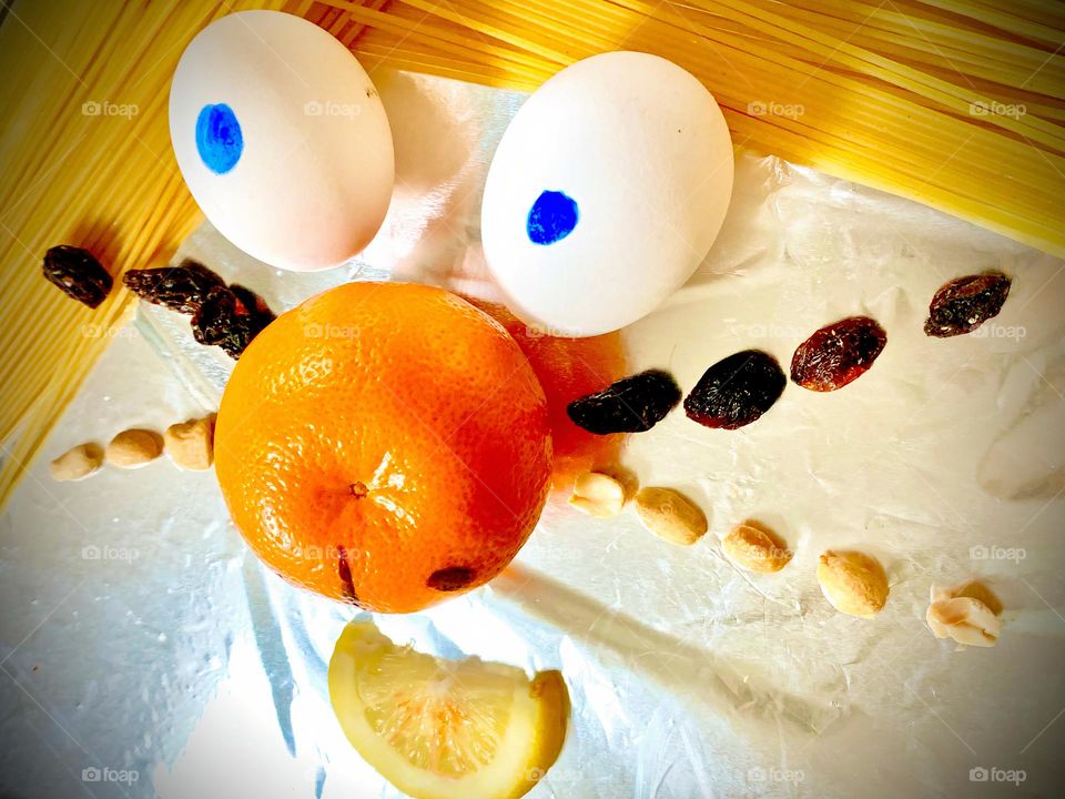 Food Funny Creature Looking At Treats Eyebrows Made Of Spaghetti, Eggs, Clementine, Lemon, Raisins, Peanuts And Dog Treats. 