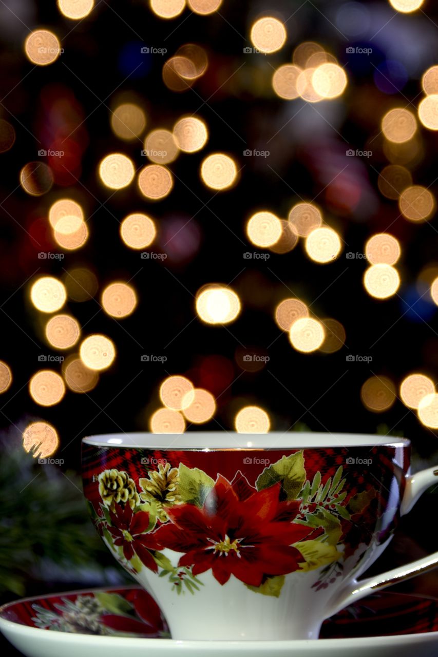 Memories frozen in time, a Christmas cup with bokeh lights in the background from the Christmas tree 