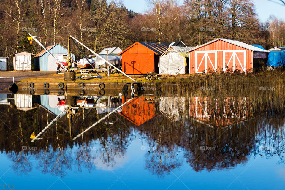 boat sheds reflected on the water on a cold winter's day