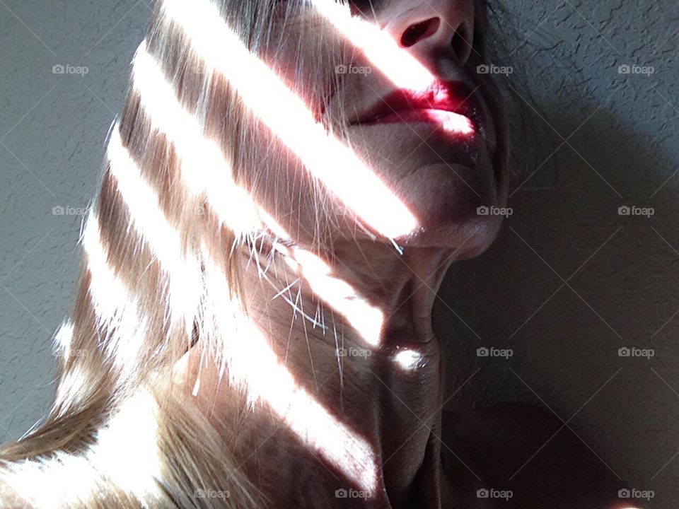 Light and shadows streak over a woman’s face.