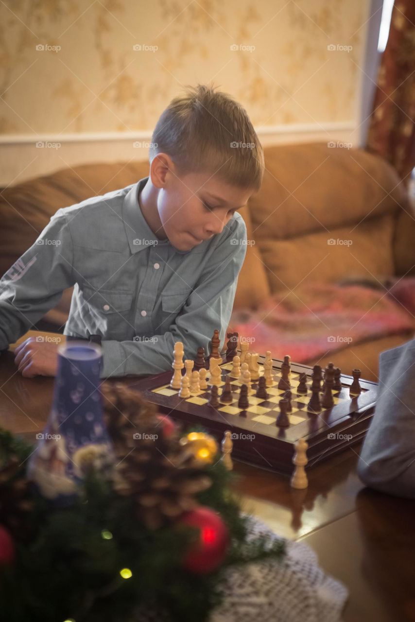 Child redhead boy playing chess