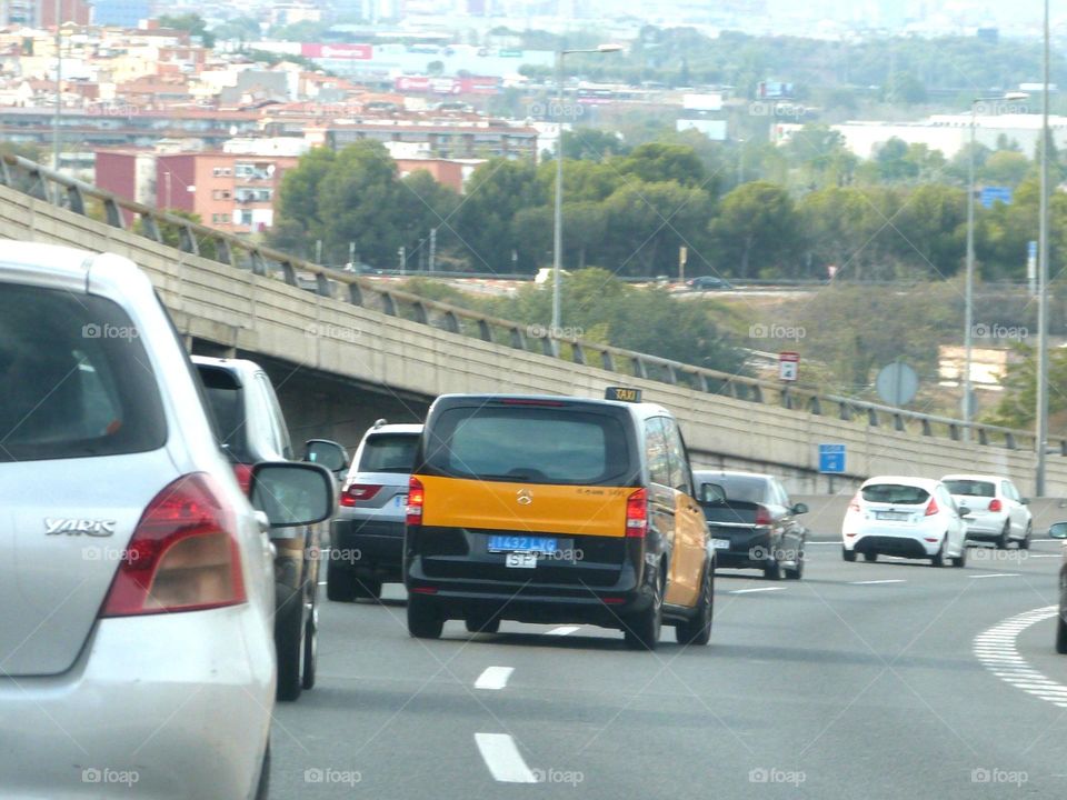 Intense road traffic approaching a major city for cars and taxis.