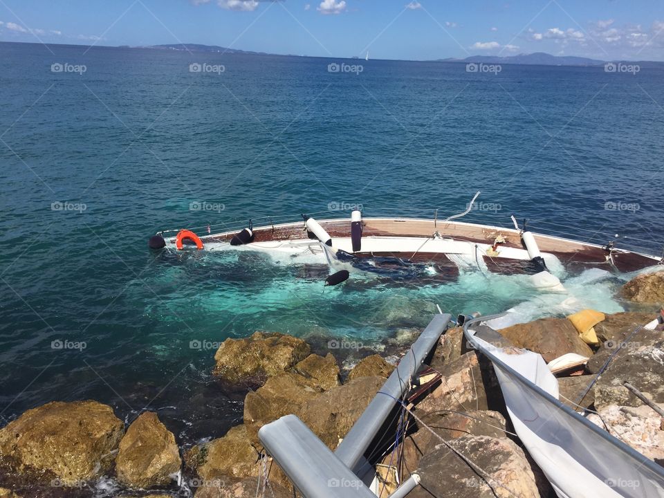 Crashed sailboat on rocks 