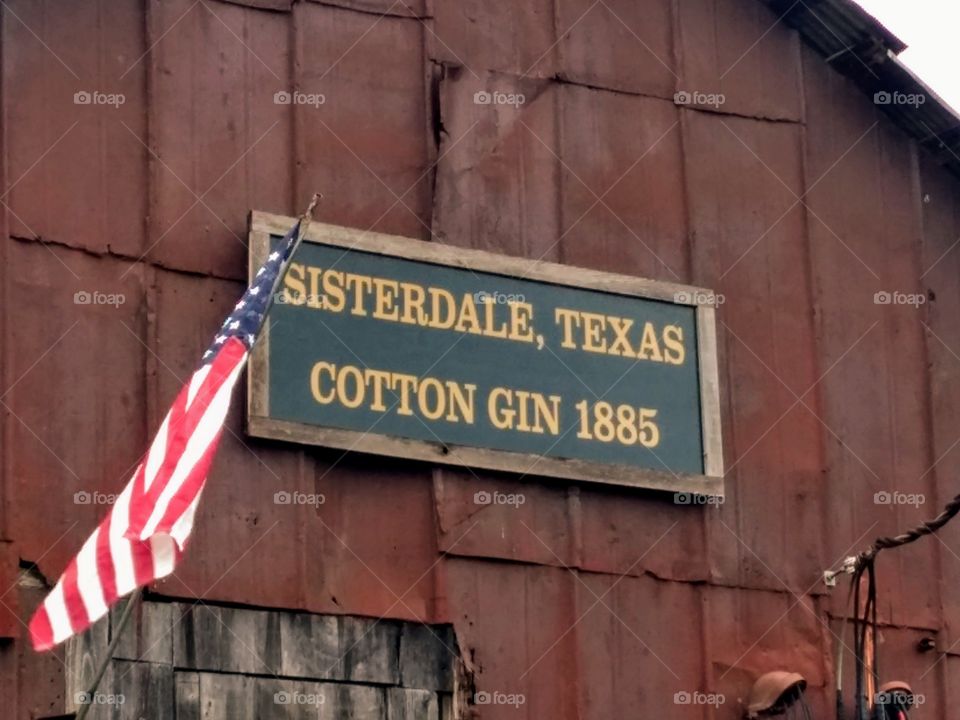 Restored old cotton gin, now Sister Creek Winery, Sisterdale, Texas Hill Country. Flag, rural, barn, old town, pioneer