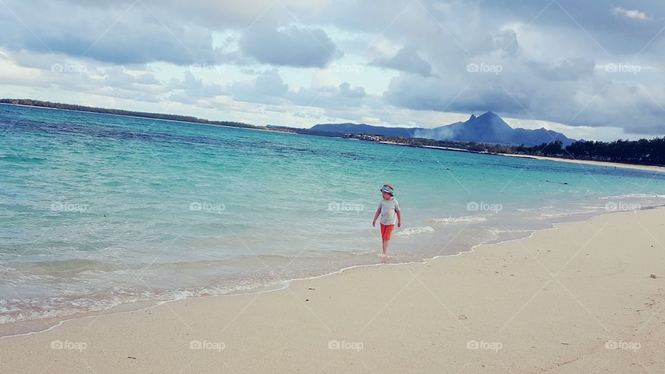little boy walks along the Indian Ocean