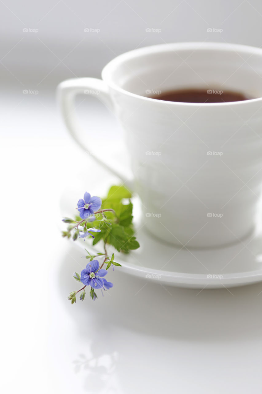 Coffee and flowers on white table. Cozy breakfast. Good morning!