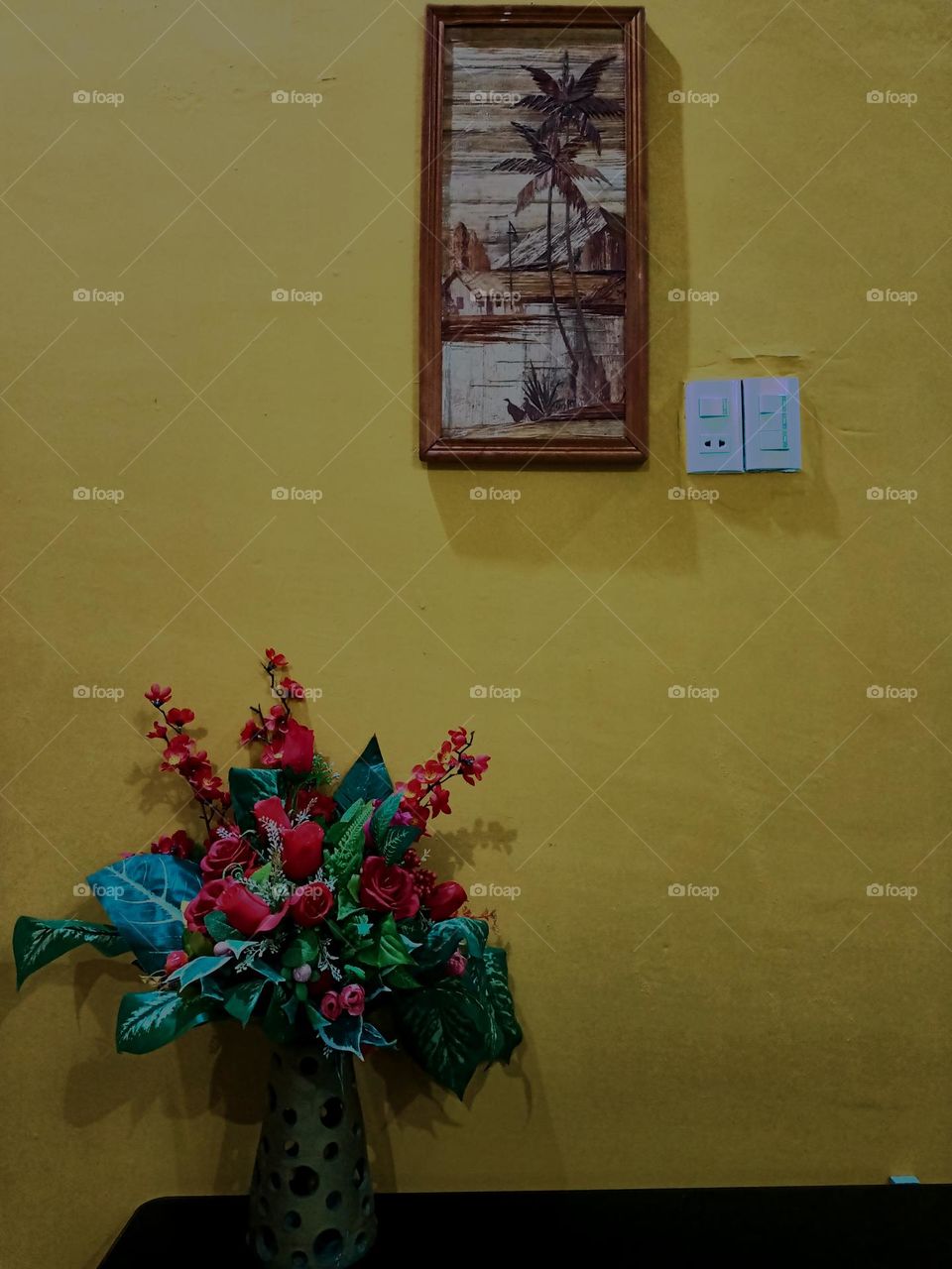 Interior room in yellow wall with single plant and single picture frame. Light background with copy space.