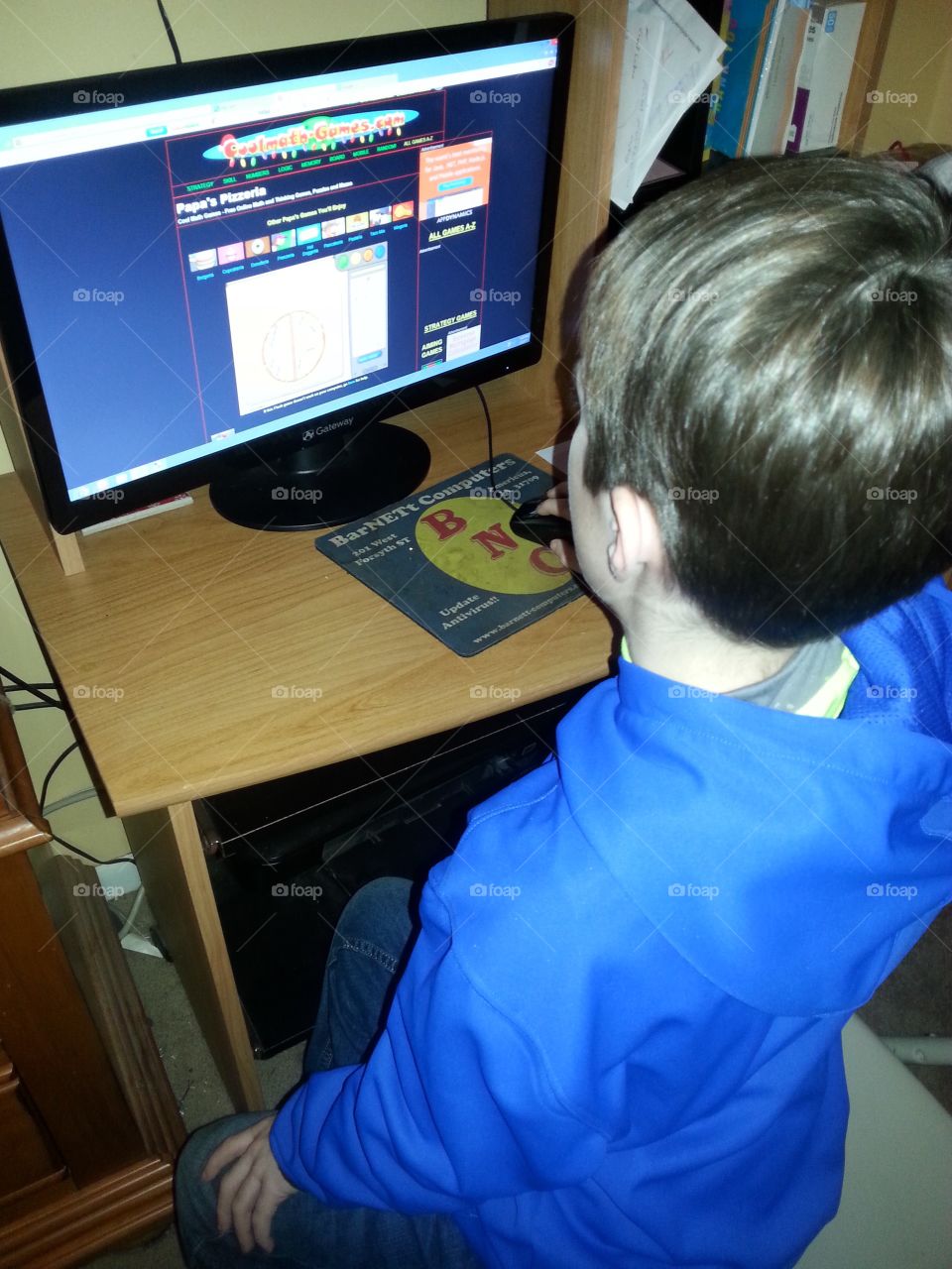 Six year old boy on the computer in a room playing.